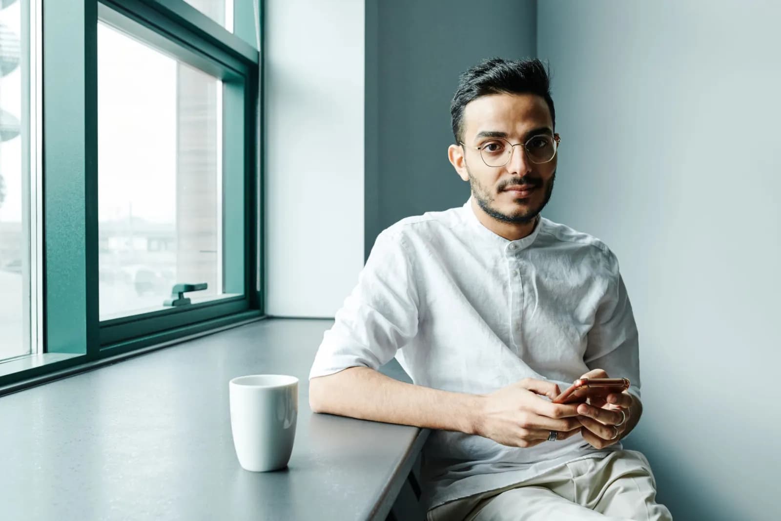 En person som sjekker mobilen i lunsjpausen på et lyst kontor