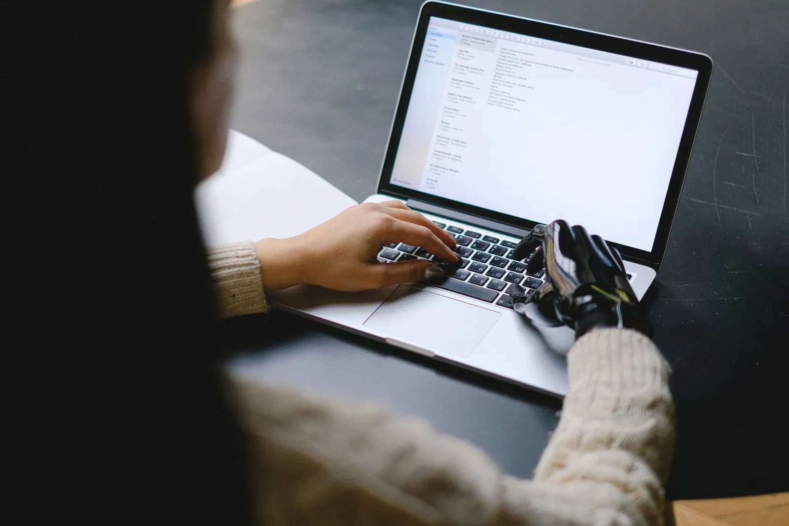 A person working on a laptop at a desk