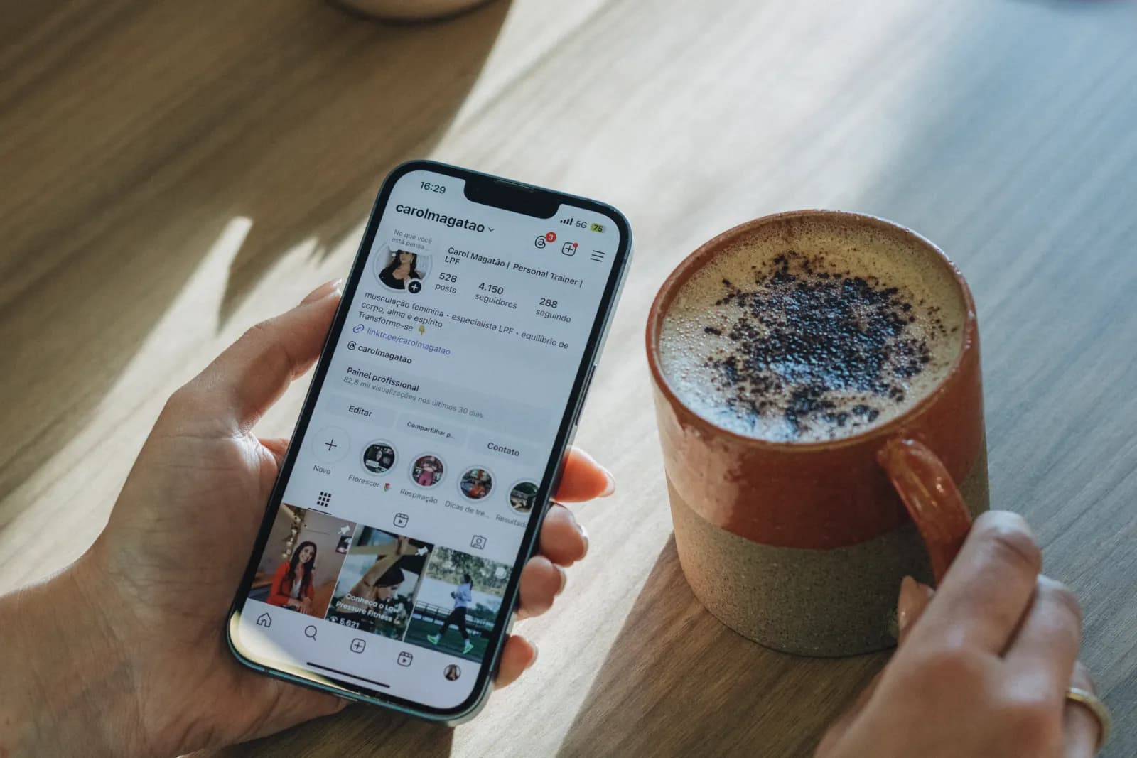 En person scrollar Instagram över en kopp kaffe