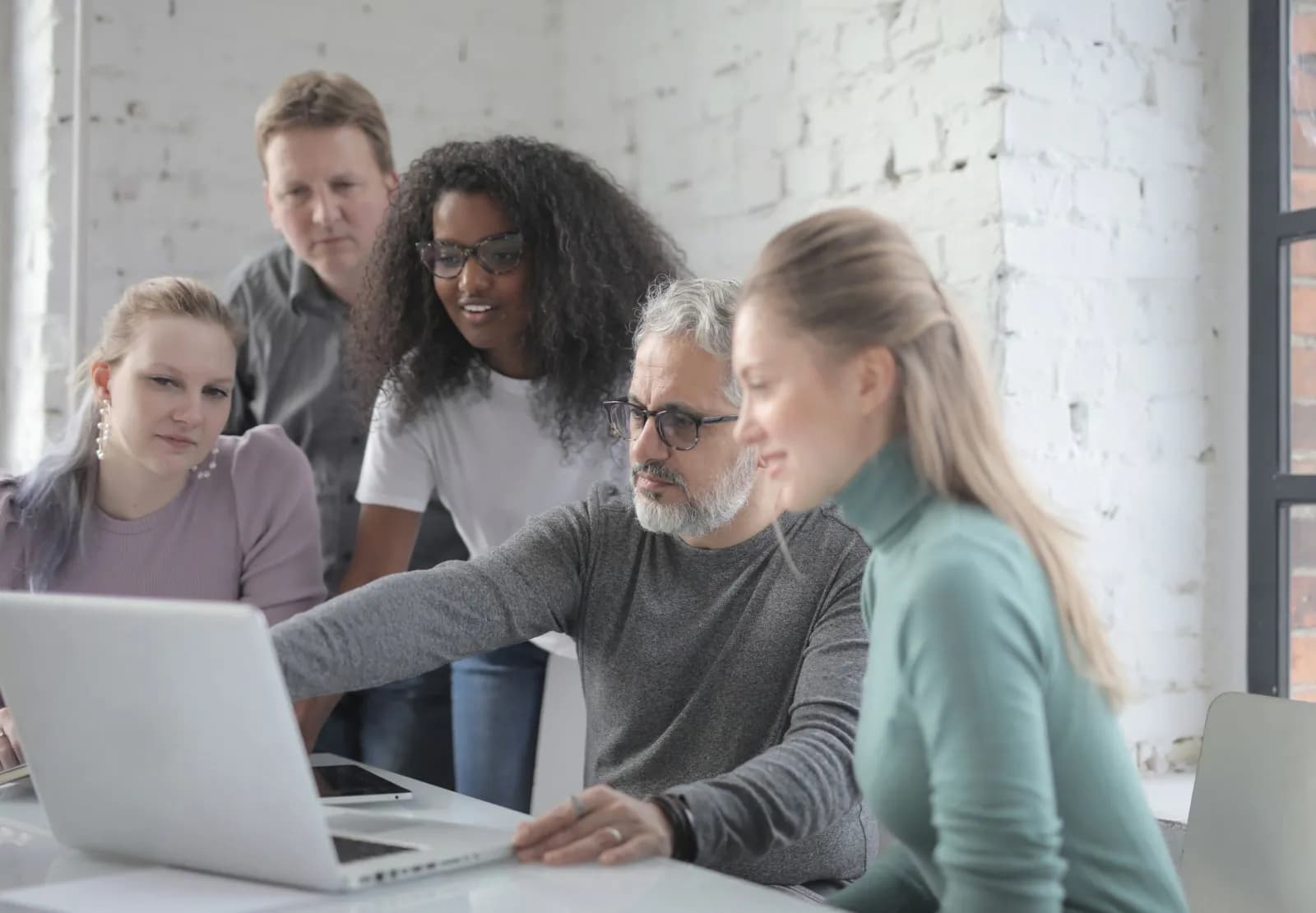 A small agency team reviewing a social media plan together on a laptop